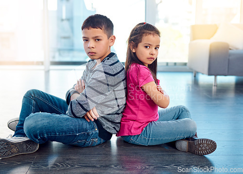 Image of Portrait, children and sitting with arms crossed after fight, anger and backs together on floor in house. Angry, brother and sister in home living room, fighting or argument, conflict or problem.