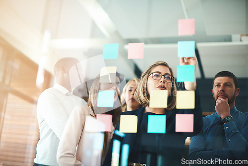 Image of Business people, brainstorming and collaboration on glass for schedule, calendar and planning goals. Woman, manager and mentor of ideas at window for sticky note feedback, agenda and timeline