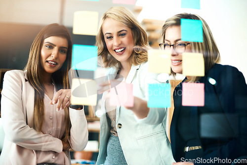 Image of Business women, brainstorming and planning schedule of target, team goals and agenda at window. Happy employees, diversity and sticky note for timeline of workflow process, calendar and project ideas