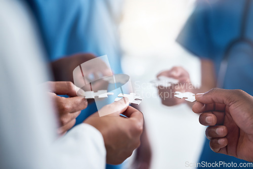 Image of Hands, puzzle and collaboration of medical doctors in hospital for team building, synergy and planning. Teamwork, nurses and jigsaw pieces for healthcare, solution and strategy, cooperation and trust