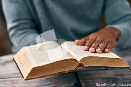 Image of Hands, faith and a man reading the bible at a table outdoor in the park for religion or belief in god. Book, story and spiritual with a male christian sitting in the garden for study or worship
