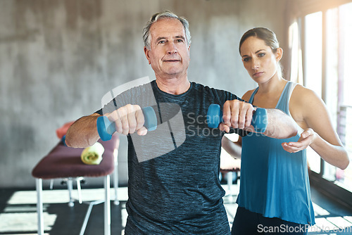 Image of Helping, dumbbell and coaching with old man and personal trainer for support, health and physiotherapy. Training, weightlifting and exercise with senior patient and female trainer for elderly workout