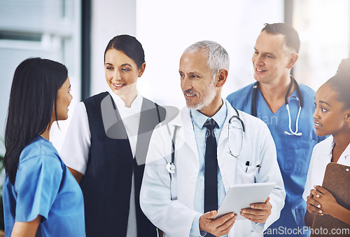 Image of Senior man, team or group of doctors with tablet, smile or leadership for discussion, planning or together in hospital. Medical men, leader and experience for teamwork, women or touchscreen in clinic