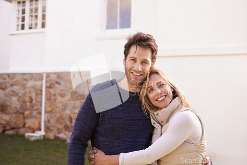 Image of New home, outdoor portrait and happy couple hug for house, real estate and property purchase, sale or investment. Mortgage, happiness and smiling woman, man or homeowner people embrace for relocation