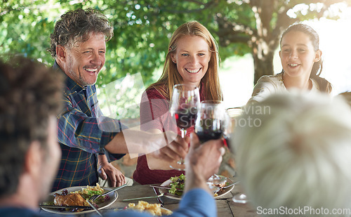 Image of Family, group and wine glass for toast at table for celebration, food and friends at lunch event. Men, women and smile together to celebrate with alcohol, glasses and support at party, dinner or home