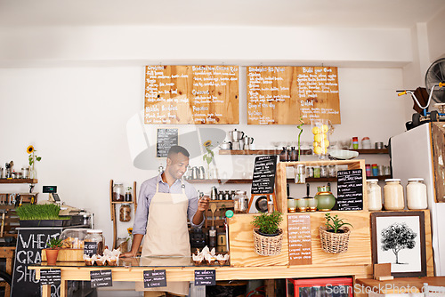 Image of Black man, coffee shop worker and phone of an entrepreneur with happiness from small business. Cafe, mobile and barista looking on music app for song with smile at bakery and restaurant feeling happy