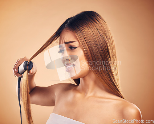 Image of Woman with flat iron, hair care fail and worried about heat damage with hairloss isolated on studio background. Electric straightener, female model with anxiety about keratin treatment and hairstyle