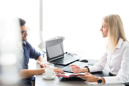 Image of Business meeting. Client consulting. Confident business woman, real estate agent, financial advisor explaining details of project or financial product to client in office.