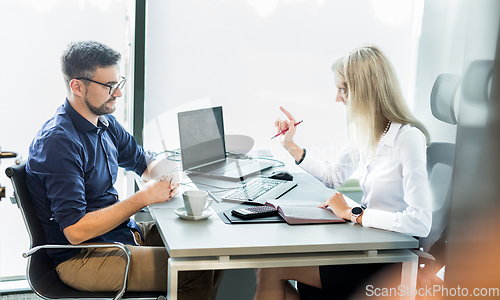 Image of Business meeting. Client consulting. Confident business woman, real estate agent, financial advisor explaining details of project or financial product to client in office.