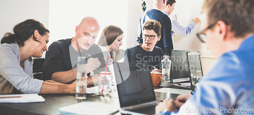 Image of Startup business and entrepreneurship problem solving. Young AI programmers and IT software developers team brainstorming and programming on desktop computer in startup company share office space.