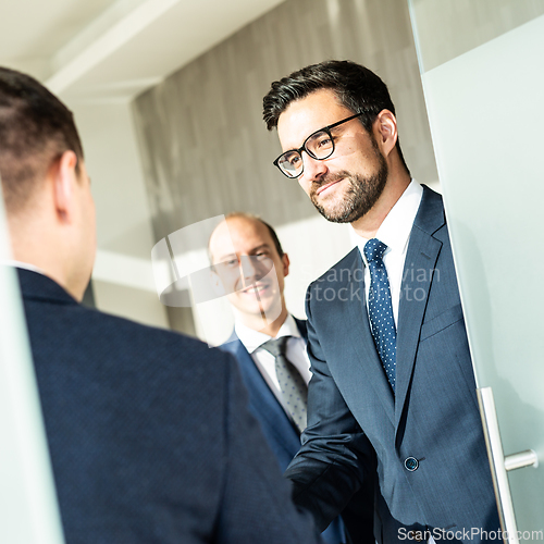 Image of Group of confident business people greeting with a handshake at business meeting in modern office or closing the deal agreement by shaking hands.