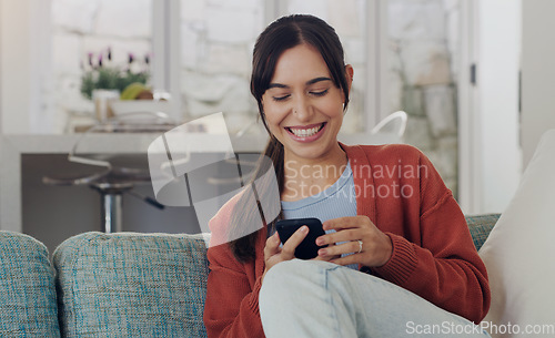 Image of Happy, woman and typing on smartphone in living room, reading social media post and funny online meme. Female person, smile and relax with cellphone, download mobile games and web connection at home