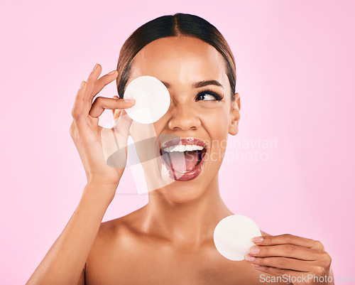 Image of Happy woman, face and cotton pad in beauty, makeup removal or skincare cosmetics against a pink studio background. Excited female person or model with cosmetic swab for cleaning or facial treatment