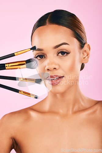 Image of Woman, portrait and makeup brushes for beauty cosmetics against a pink studio background. Isolated female person or model with cosmetic tools or equipment for grooming, products or facial treatment