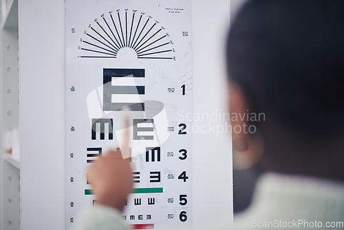 Image of Eye care, medical and chart for a vision test for prescription lens glasses in an optometry clinic. Ophthalmology, healthcare and back of optometrist doing an optical exam with letter board in store.