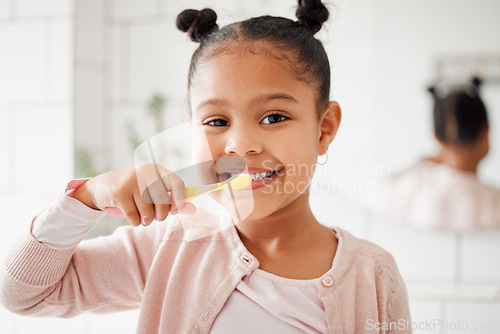 Image of Child, toothbrush and brushing teeth in a home bathroom for dental health and wellness with smile. Face portrait of african girl kid cleaning mouth with a brush for morning routine and oral self care