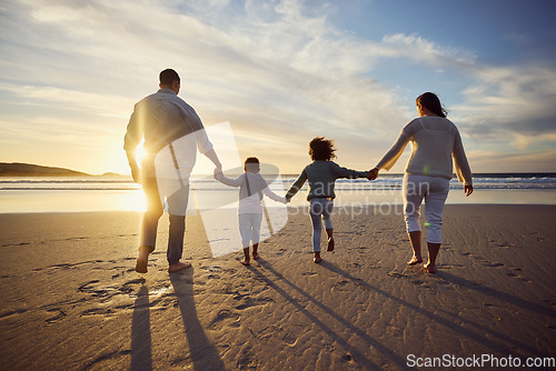 Image of Sunset, beach and back of family holding hands and walking on holiday, summer vacation and weekend. Nature, travel and mother, father and children by ocean for bonding, adventure and quality time