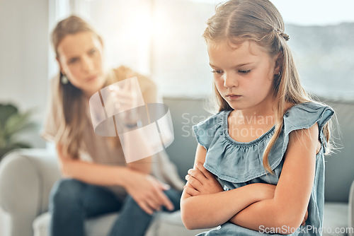 Image of Angry lecture from mom, sad child and discipline in living room, problem with naughty girl behaviour in home. Scolding, punishment and frustrated mother, stubborn kid and communication with anger.