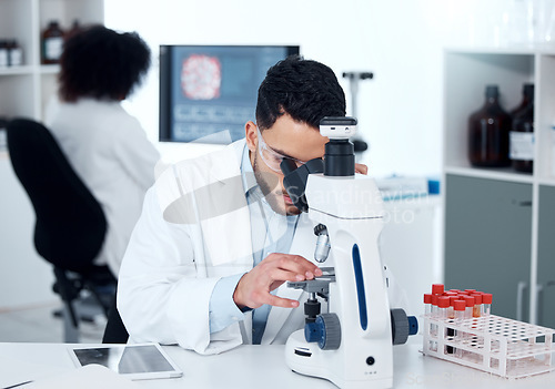 Image of Science, particles and scientist analyzing with a microscope in a medical laboratory with concentration. Biotechnology, pharmaceutical and male researcher working on scientific project for healthcare
