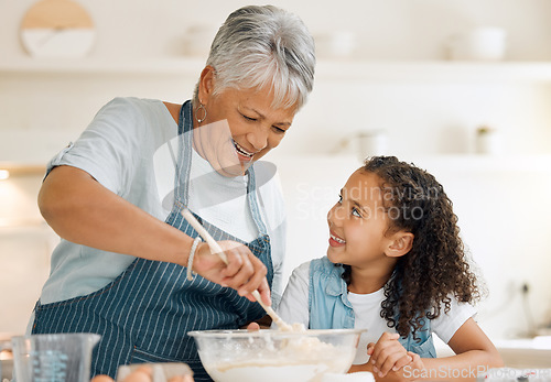 Image of Grandmother, happy or child baking in kitchen as a happy family with young girl learning cookies recipe. Mixing cake, development or grandma smiling or teaching kid to bake with eggs, butter or flour