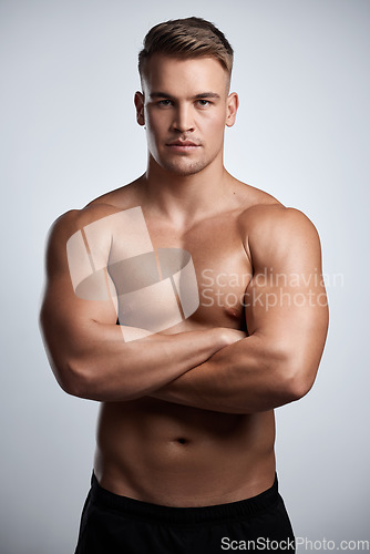 Image of Portrait, man and bodybuilder with arms crossed on studio background, backdrop and topless abs. Sexy, serious and strong male model, sports athlete and fitness for exercise, confidence and muscles