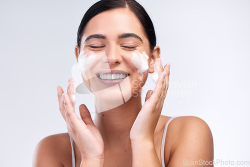 Image of Skincare, foam wash and woman in a studio for natural, cosmetic and beauty hygiene routine. Wellness, health and female model cleaning her face with a facial cleanser isolated by a white background.