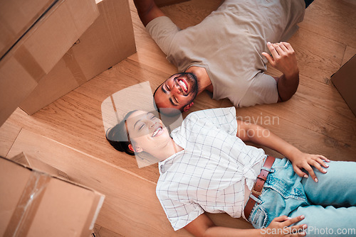 Image of Top view, happy couple and moving into new home on floor, ground and relax from packing boxes. Man, woman and taking a break in house from property mortgage, real estate and investment of apartment