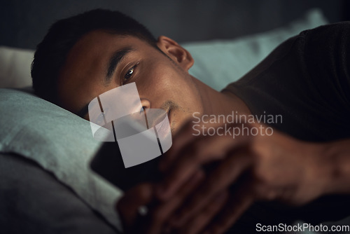 Image of Night, scroll and man in bed with phone surfing internet, social media post or texting with insomnia in home. Wake up, browse and male in dark bedroom with cellphone, mobile game and digital app.