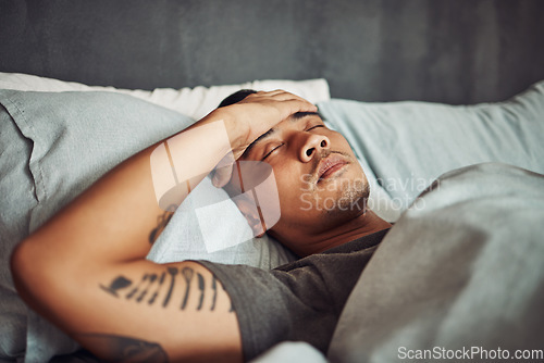 Image of Tired, rest and sick man sleeping in the bedroom while in recovery or healing in his apartment. Burnout, illness and male person with a headache or fever taking a nap in bed at his modern home.