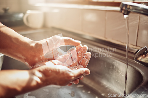 Image of Soap, water and cleaning hands in kitchen for hygiene, health and wellness in home to clean skin. Tap, sink and skincare, hand wash with cleansing foam and bubbles for germ and bacteria protection.