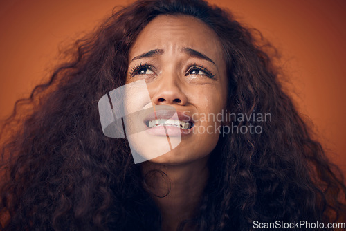 Image of Woman, crying and sad face in studio with anxiety, mental health problem and depression. Headshot of african female person on a brown background for cry emoji, psychology and broken heart with tears