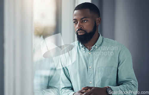 Image of Idea, window and a business black man thinking or planning in his professional office at work. Flare, problem solving and decision with a serious young male employee standing alone in the workplace