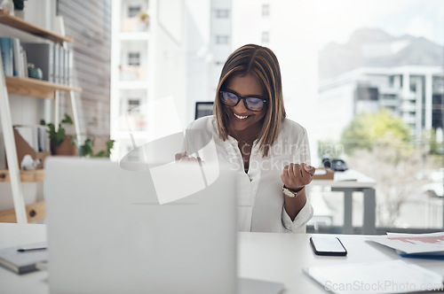 Image of Business woman, success and laptop to celebrate profit, win or achievement in a modern office. African female entrepreneur at a desk with motivation and technology for bonus, victory and promotion