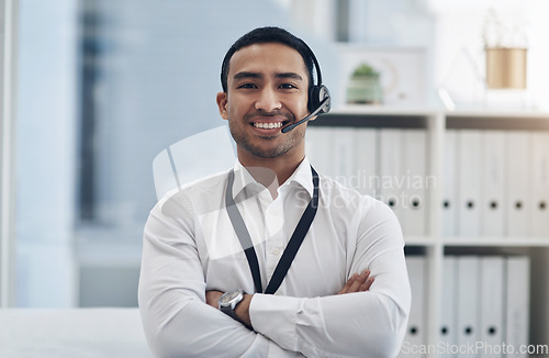 Image of Smile, headset and a man in a call center for customer service, telemarketing or help desk. Asian male person with arms crossed for contact us, telecom support or crm consultant or agent at a company