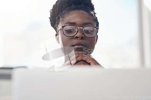 Image of Thinking, planning and business woman on computer for solution, research and serious, focus or job decision. Reading, review and choice of african person or analyst on laptop for data problem solving