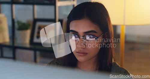 Image of Computer, night and face with a woman editor working in her office for a journalism or news report. Focus, editing and reporting with a young journalist at work on a desktop for online content