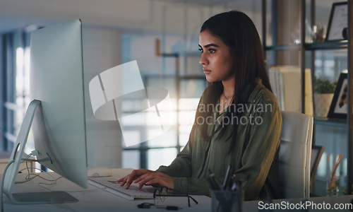 Image of Computer, night and focus with a woman editor working in her office for a journalism or news report. Typing, editing and reporting with a young journalist at work on a desktop for online content