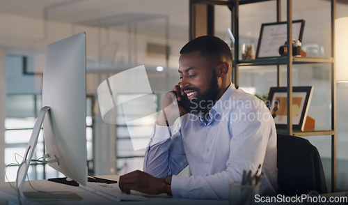 Image of Business man, phone call and computer at night while working at a desk for communication and crm. Black male entrepreneur with a smartphone for networking, connection and conversation with a contact