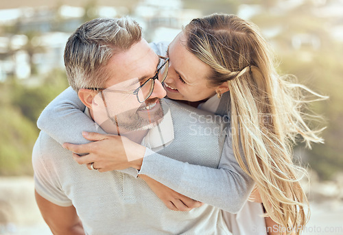 Image of Hug, love and couple with a smile, beach or romance with relationship, marriage or summer vacation. Romantic, mature man or woman embrace, seaside holiday or bonding with happiness or loving together