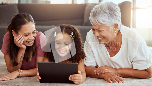 Image of Mother, girl and grandmother with tablet, floor and happy for meme, movie or social media app in living room. Mama, kid and senior woman with touchscreen with smile, reading or learning on internet
