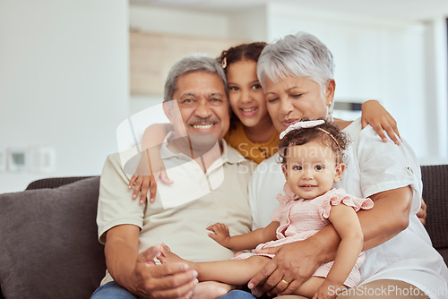 Image of Home, grandparents hug and family with children and happiness on a living room couch. Fun, baby smile and bonding with childcare, love and kids together with a young girl and newborn on a house sofa