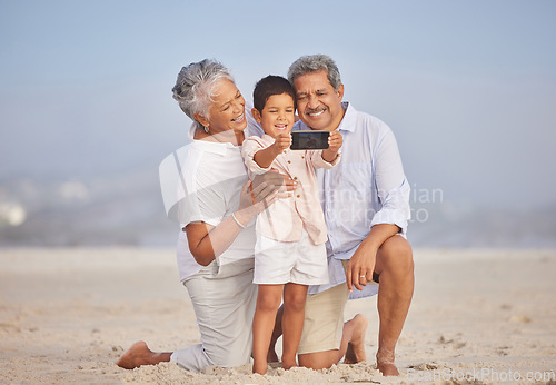 Image of Selfie, travel and grandparents with child at beach for vacation, bonding and generations. Picture, happy and young boy with senior man and woman in nature for smile, happiness and technology