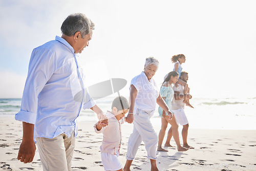 Image of Big family, vacation and holding hands walking on beach for fun bonding, holiday or weekend together in nature. Grandparents, parents and children on ocean walk by the coast on mockup space outdoors