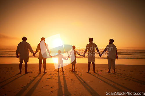 Image of Family, holding hands beach at sunset and solidarity, grandparents travel with parents and kids with orange sky. Back, generations and men, women and children outdoor with silhouette and vacation