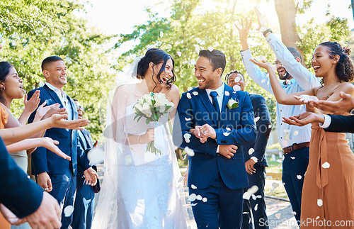 Image of Happy, wedding ceremony and couple walking with petals and guests throw in celebration of romance. Romantic, flowers and bride with bouquet and groom with crowd celebrating at outdoor marriage event.