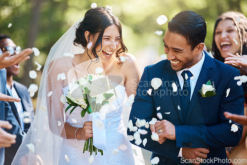 Image of Love, wedding and couple walking with petals and guests throwing in celebration of romance. Happy, smile and young bride with bouquet and groom with crowd celebrating at the outdoor marriage ceremony