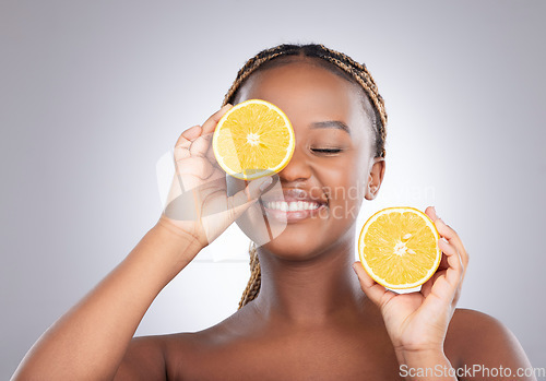 Image of Beauty, orange and cover with black woman in studio for natural, cosmetics or vitamin c. Nutrition, skincare and detox with face of female model on grey background for citrus fruit and health product