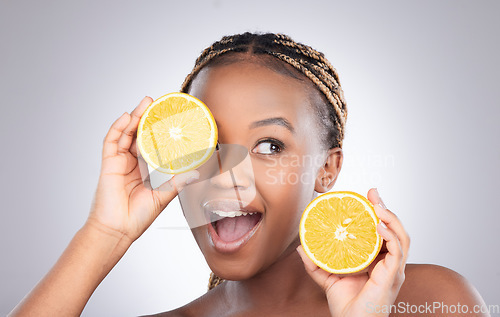 Image of Glow, orange and skincare with black woman in studio for natural, cosmetics and vitamin c. Nutrition, diet and detox with face of female model on grey background for citrus fruit and health product