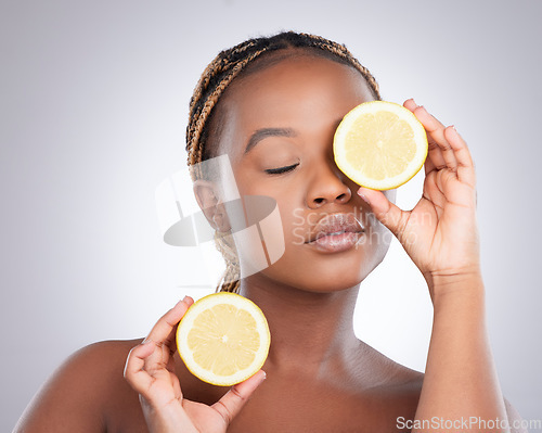 Image of Beauty, lemon and skincare with black woman in studio for natural, cosmetics and vitamin c. Nutrition, diet and detox with face of female model on grey background for citrus fruit and health product