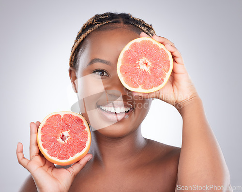 Image of Beauty, grapefruit and skincare with portrait of black woman in studio for natural, cosmetics or vitamin c. Nutrition, diet and detox with model on grey background for citrus fruit and health product